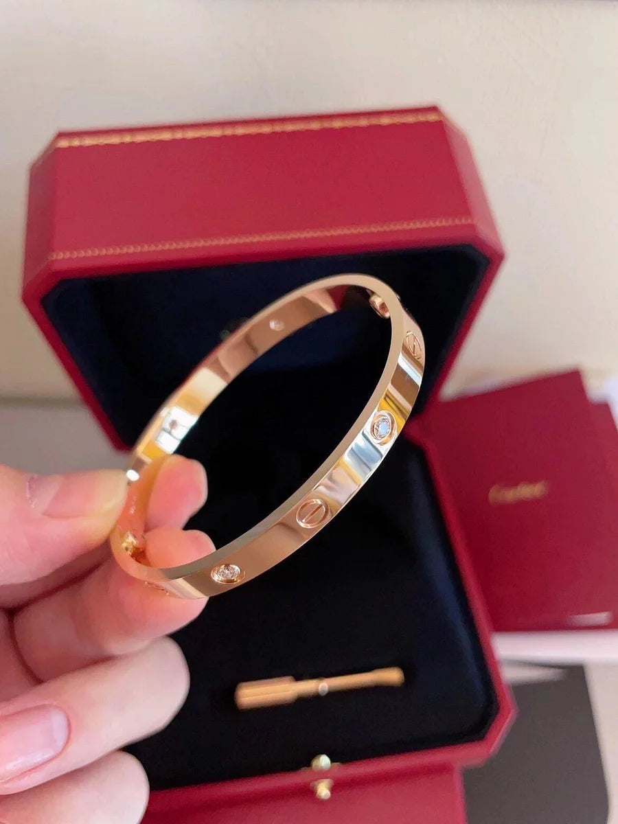 Ensemble deux pièces de la collection LOVE : un bracelet serti de 4 diamants et une bague sertie de 8 diamants.