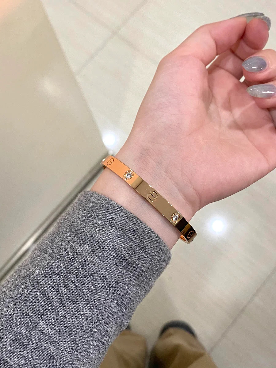 Ensemble deux pièces de la collection LOVE : un bracelet serti de 4 diamants et une bague sertie de 8 diamants.